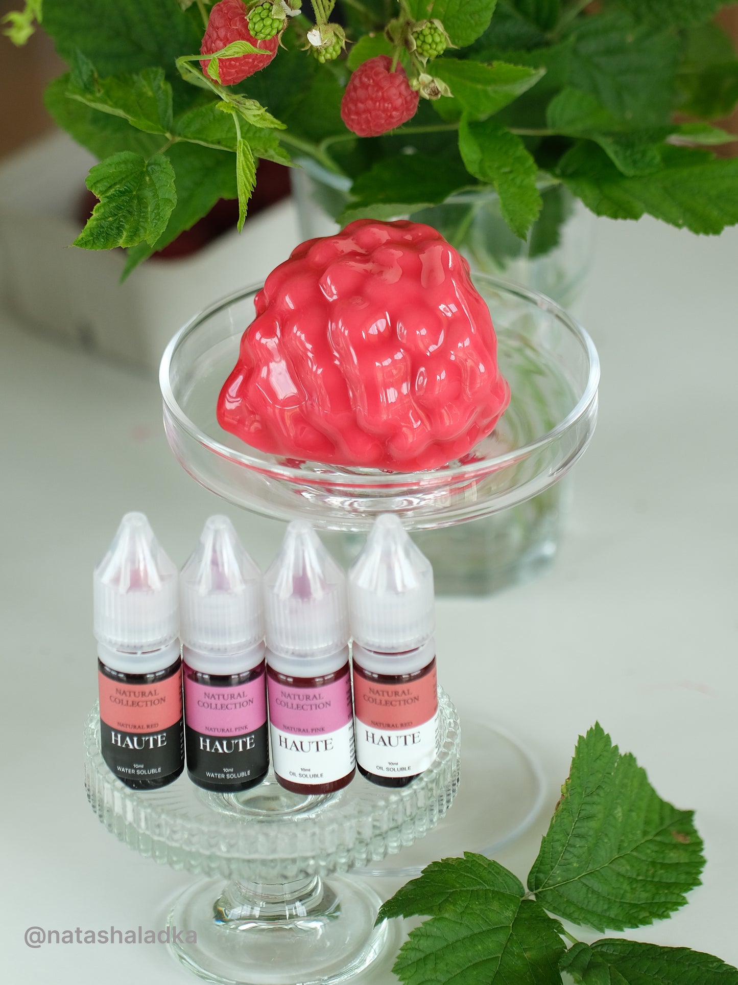 Set of Haute liquid-gel food color bottles with a raspberry realistic dessert and green leaves in the background. Best Natural Haute Food Colors by Ksenia Penkina, Vegetable Colours, Liquid Gel, Water Soluble, Oil Soluble, Fat Soluble Gel, Food Colouring, Chefrubber, Colourmill, Chefmaster, Silikomart, Pavoni, Decorelief, Matfer, PastryClass, Valrhona, Cacao Barry, For Macarons, For Glazing